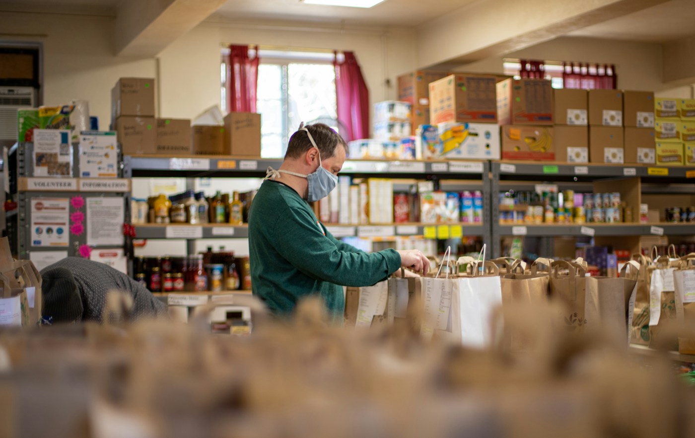 A volunteer packing food bags at a community pantry
